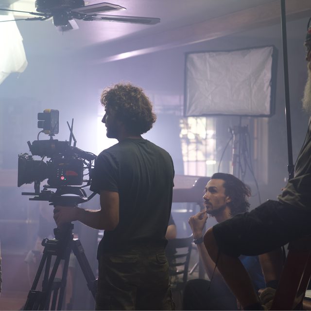 The camera operator lines up a shot in the hazy bar