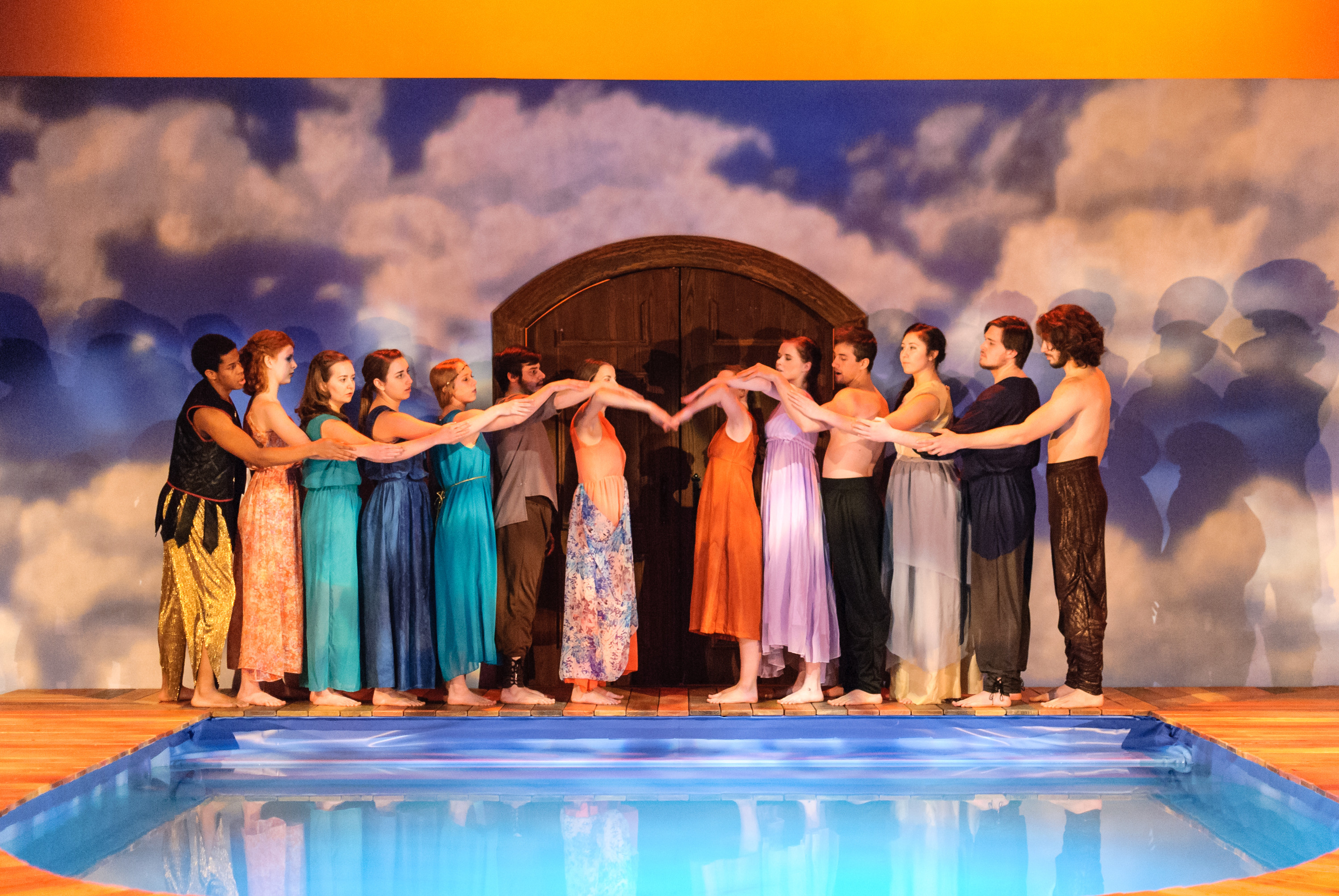 The ensemble of Metamorphoses at Oklahoma City University, joined hand to hand along the edge of the onstage pool